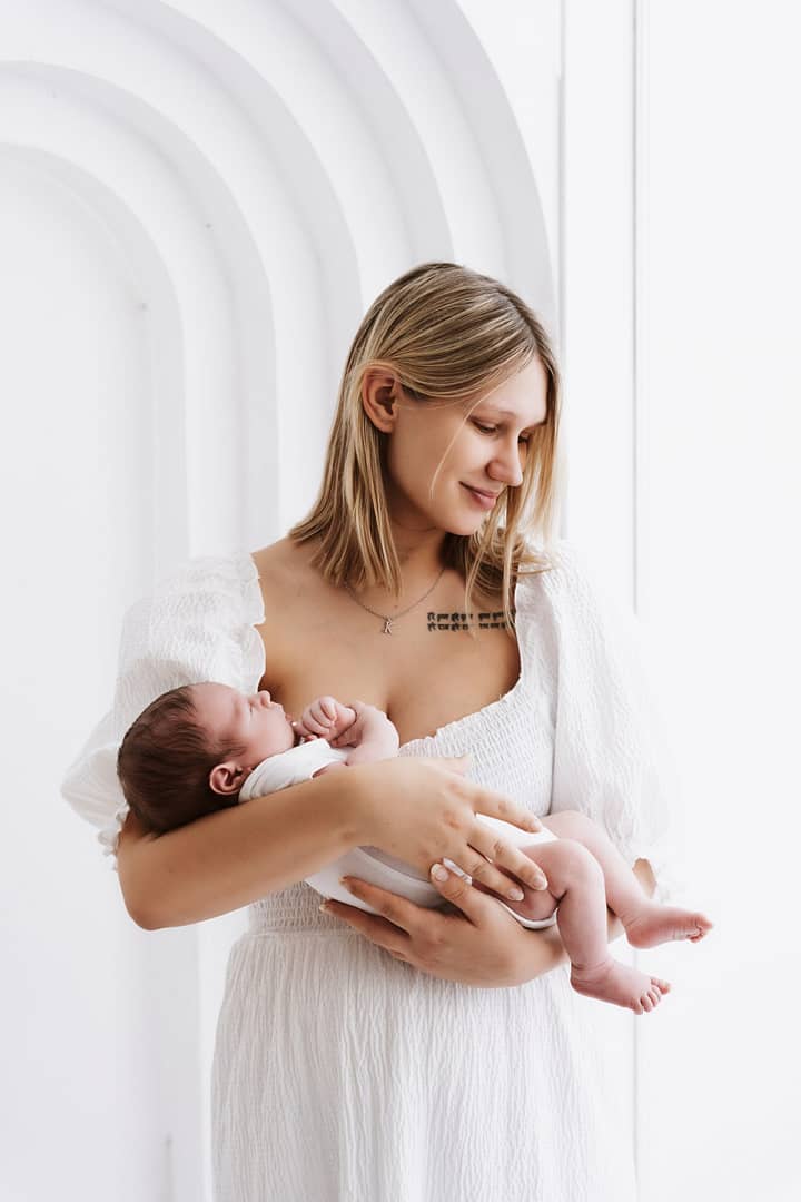"Mama nežno drži svojega dojenčka v naročju."